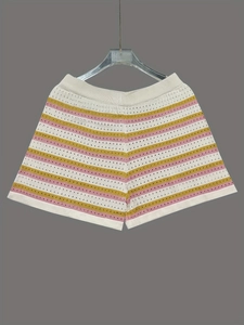Détail macro d'un short en maille taille haute avec rayures colorées et texture ajourée aérée