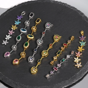 Close-up of gold and silver pendants with colored zircons on a round shale plate