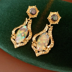 Vue rapprochée de boucles d'oreilles vintage en or avec incrustations de nacre ovale