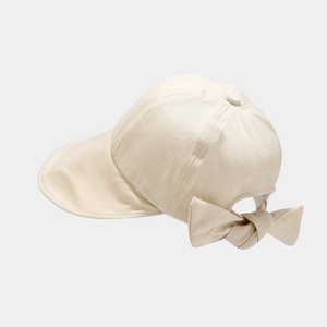 Detail view of the elegant beige sun hat featuring a large decorative rear bow
