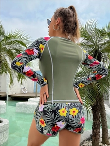 Detail of long-sleeve surfing swimsuit featuring tropical floral prints and white stitching