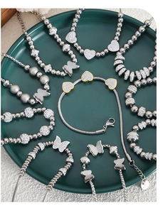 Macro view of crystal butterfly necklaces and heart pendants in a ceramic tray