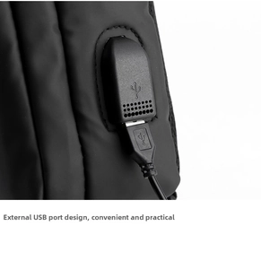 Close-up of waterproof black crossbody bag featuring external USB charging port and cable