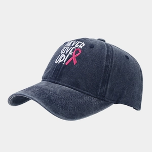 Détail de la casquette marine avec broderie NEVER GIVE UP et ruban rose de soutien