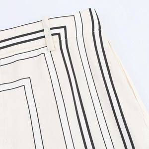 Detailansicht des elastischen Hosenbunds und geometrischen Drucks auf beiger Satinhose
