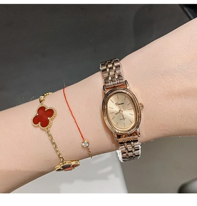 Close-up of elegant gold quartz watch with a metal link strap worn on woman's wrist