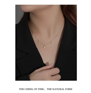 Close-up of a gold 925 silver necklace with lock and key pendants on a model