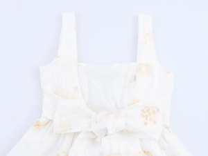 Dettaglio posteriore dell'abito jacquard bianco con un grande fiocco dorato elegante