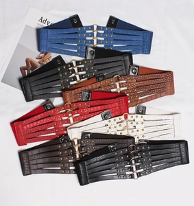 Detail of layered cut-out waist belt with gold rivets and metallic circular buckle