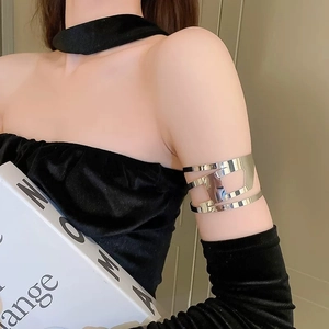 Close-up of silver hollow geometric metal arm cuff on upper arm with a minimalist style