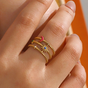 Gold layered beaded ring with pink moon and blue sun pendants in a sun-moon theme