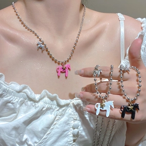 Dettaglio dei ciondoli a forma di pony in rosa, bianco e nero con stelle dorate