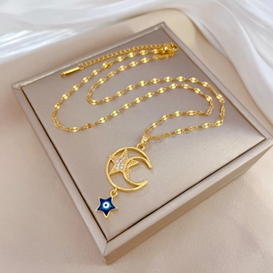 Luxurious gold star and moon necklace with blue evil eye pendant on beige silk