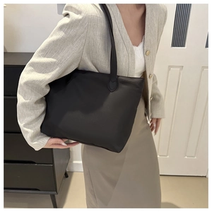 Detailed shoulder view of a black nylon tote bag for women showing size and strap comfort