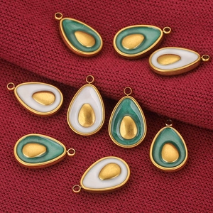 Eight gold-edged teardrop avocado charms in white and green on red knitted fabric