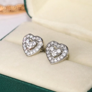 Macro shot of silver heart stud earrings with pave crystals in a premium velvet gift box