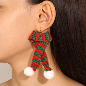 Close-up of Christmas themed mini scarf knitted earrings with red green stripes and white pom-poms