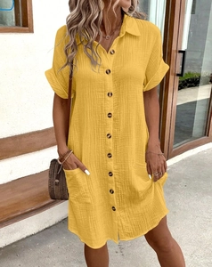 Detail of yellow cotton linen shirt dress featuring button-up front and textured fabric