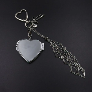 Detailed silver metal heart pendant with mesh fringe and bow detail on black background