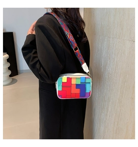 Detail of the colorful geometric pattern and wide woven strap on the small square crossbody bag