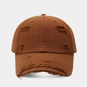 Close-up of distressed vintage baseball cap with frayed edges and ripped cotton texture