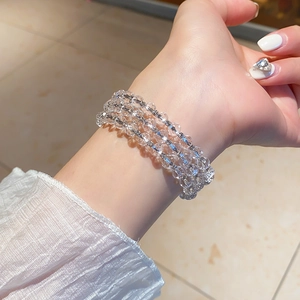 Detail of multi-layer beaded bracelet with crystal facets and silver spacer beads on wrist