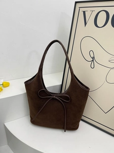 Retro dark brown matte bucket bag with butterfly ribbon on a stylish white staircase