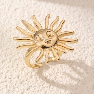 Close-up of a vintage style adjustable sun face ring with golden rays on white texture