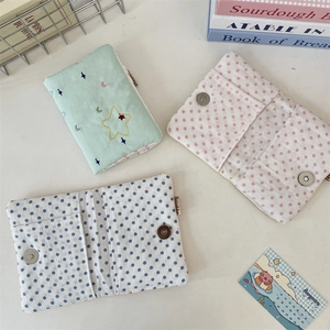 Detail of fabric passport holders with star embroidery and magnetic closures in three colors