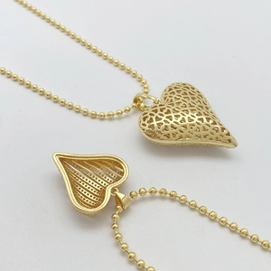 Detailed view of an openable gold striped heart locket pendant with a sleek bead chain