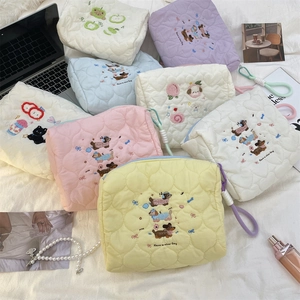 Detailed embroidery and heart quilting on cream travel cosmetic bags with zipper