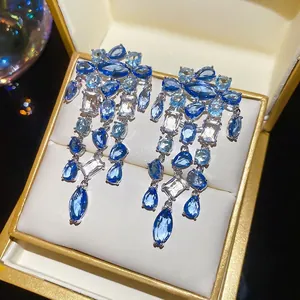 Elegante silberne Quastenohrringe mit blau-weißen Zirkonia-Kristallen in Tropfenform