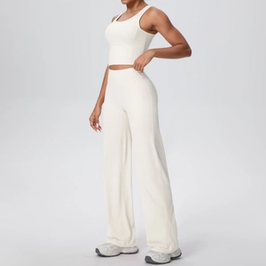 Dettaglio dei pantaloni da yoga bianco crema a gamba larga e canotta corta coordinata