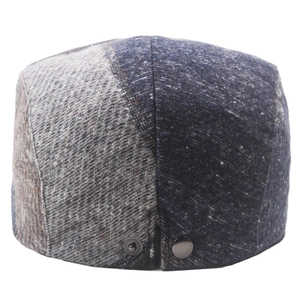 Detail view of the retro wool blend newsboy hat with metal snaps and textured patchwork