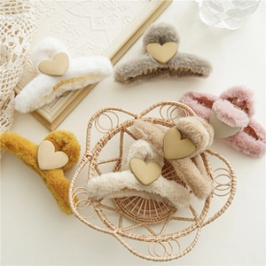 Dettaglio di sei mollette per capelli in peluche con cuori dorati in vari colori pastello
