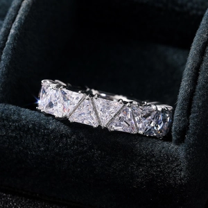 Macro shot of triangle-cut cubic zirconia stones on full eternity ring with silver band