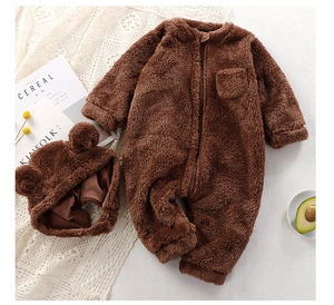 Flat lay of baby winter warm fleece jumpsuit and cute bear ear hat in coffee brown