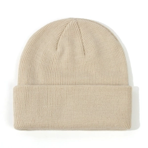 Macro view of a soft beige knitted baby beanie featuring detailed ribbing texture