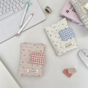 Floral and checkered cotton book covers in pink and blue on a clean desktop