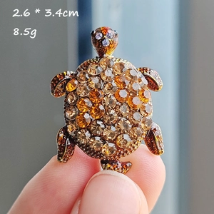 Detail view of a turtle brooch with gradient crystals measuring 2.6 by 3.4 cm
