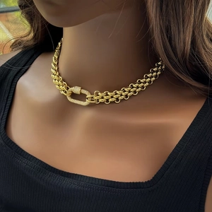 Detailed view of 18K gold chunky braided chain with micro-pave rhinestone horseshoe clasp