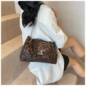 Detailed view of leopard print shoulder bag with silver chain and iconic metal T-bar buckle