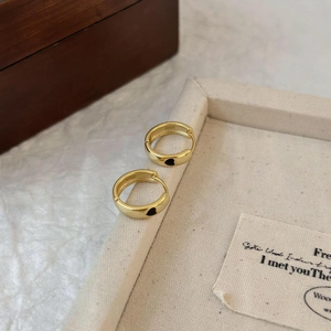 Detail showing gold plated S925 silver heart earrings on a beige canvas tray