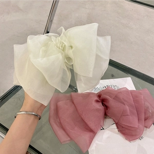 Detail of elegant organza oversized bow hair clips in beige and dusty pink colors