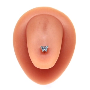 Piercing de langue papillon argenté avec cristaux bleus sur modèle silicone