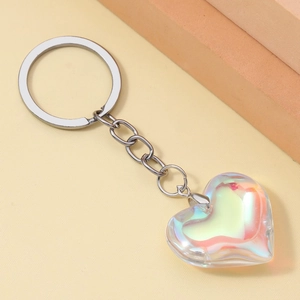 Macro shot of 3D iridescent resin heart keychain with shiny silver metal ring and chain