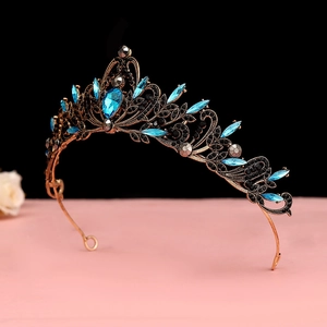 Detail of vintage bronze crown with large sky blue pear-shaped gem and black crystals