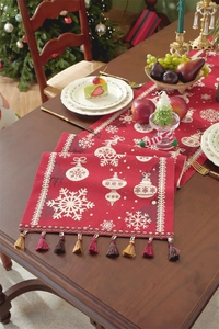 Detail of red Christmas table runner with snowflake patterns and festive tassels