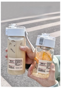Close-up of minimalist clear plastic water bottles with white lids in an outdoor setting