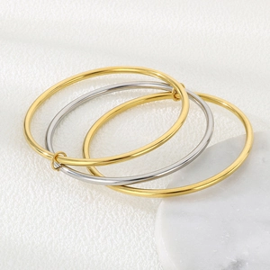 Detail of three-layer interlocked 3mm stainless steel bangles in gold and silver finish